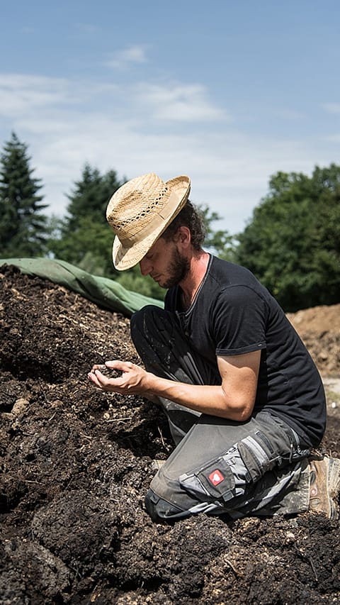 gardener_kneels_on_compost.jpg